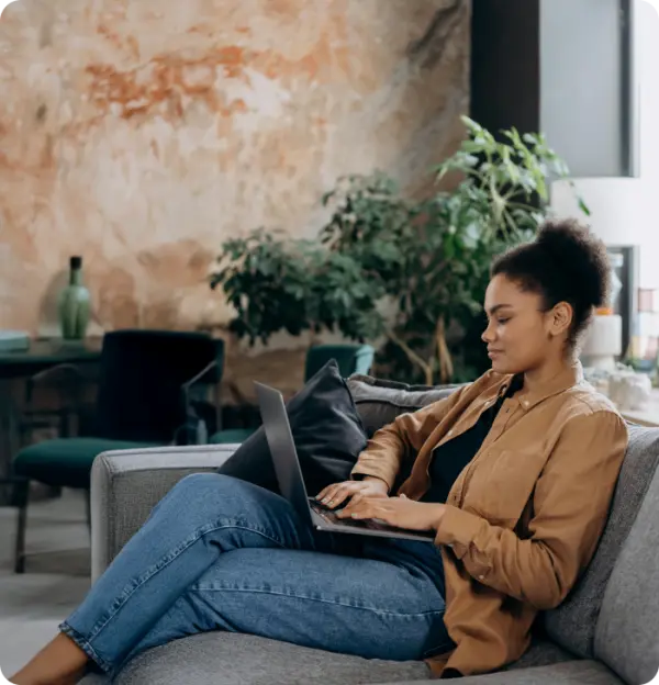 Girl sitting on sofa using laptop